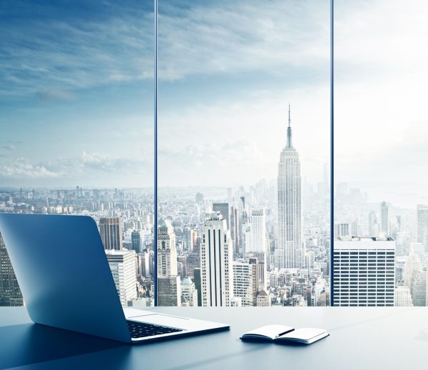 laptop, cup and diary on table in office